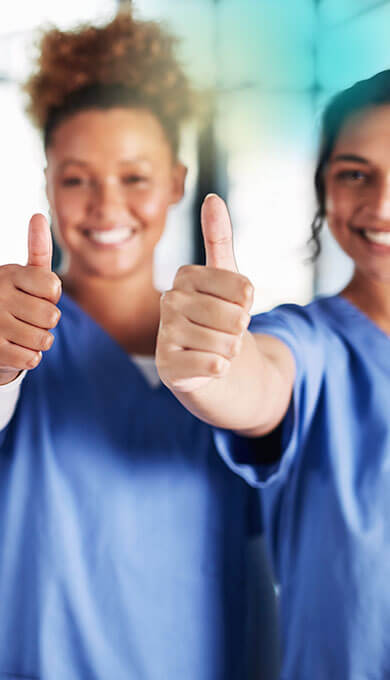 L&auml;chelnde Krankenschwestern, die das OK-Zeichen zeigen.