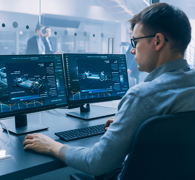 Ingenieur arbeitet konzentriert an zwei Monitoren mit CAD-Software in einem modernen B&uuml;ro.