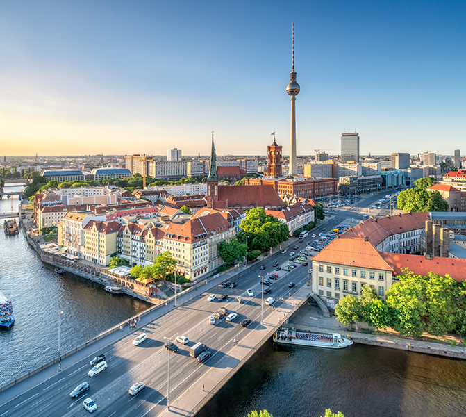 Stadtansicht von Berlin bei Sonnenuntergang mit Fernsehturm, Spree und historischen Geb&auml;uden.