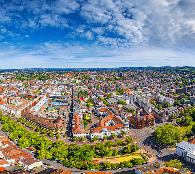 Panoramaaufnahme der Stadt Bielefeld mit modernen Geb&auml;uden und gr&uuml;nem Umfeld.