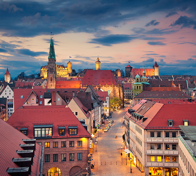 Stimmungsvolle Ansicht der N&uuml;rnberger Altstadt mit historischen Geb&auml;uden und Burg im Abendlicht.