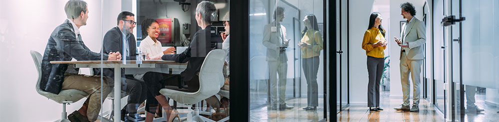 Menschen im Meetingraum und im Flur im Gespr&auml;ch &ndash; Zusammenarbeit und Teamarbeit im Fokus.