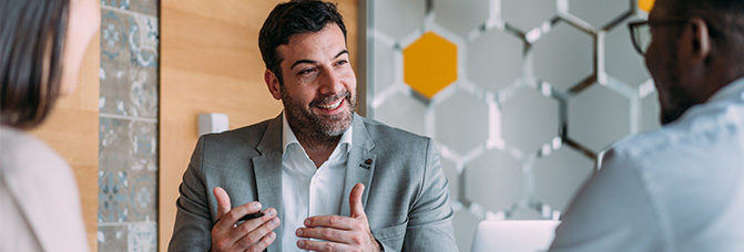 Personalberater spricht im Meeting mit zwei Kandidaten &ndash; Austausch &uuml;ber Karrierechancen im Legal-Sektor.