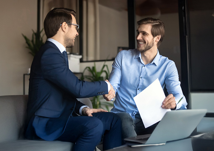 Shake Hands auf einer B&uuml;rocouch nach Einstellung